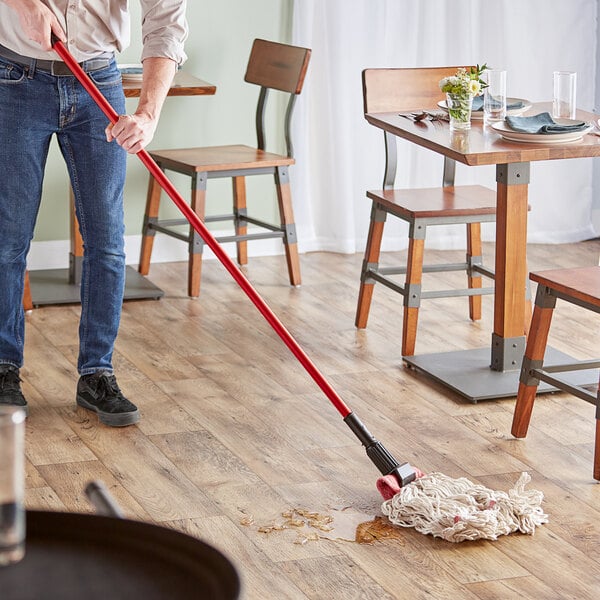 A person mopping the floor with a Lavex Wet Mop.