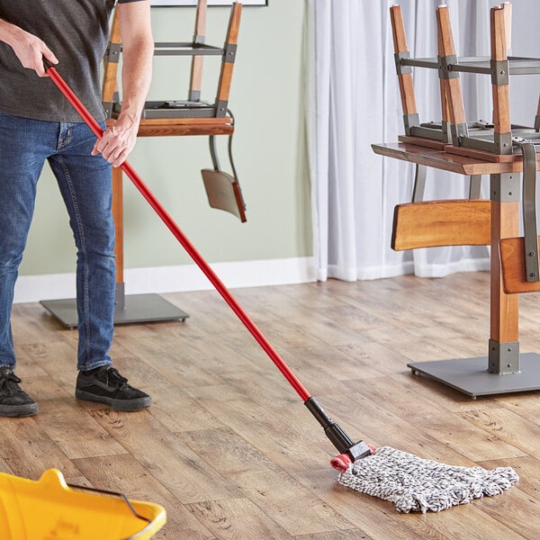 A man using a Lavex Wet Mop Kit to mop a floor in a professional kitchen.