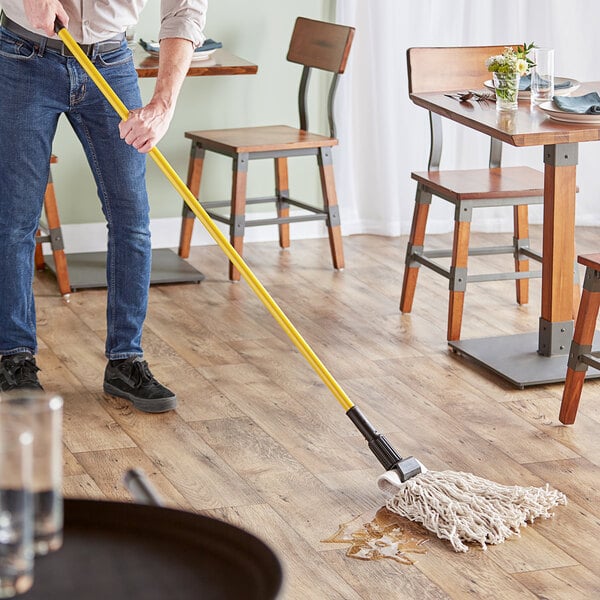 A person mopping the floor with a Lavex wet mop kit.