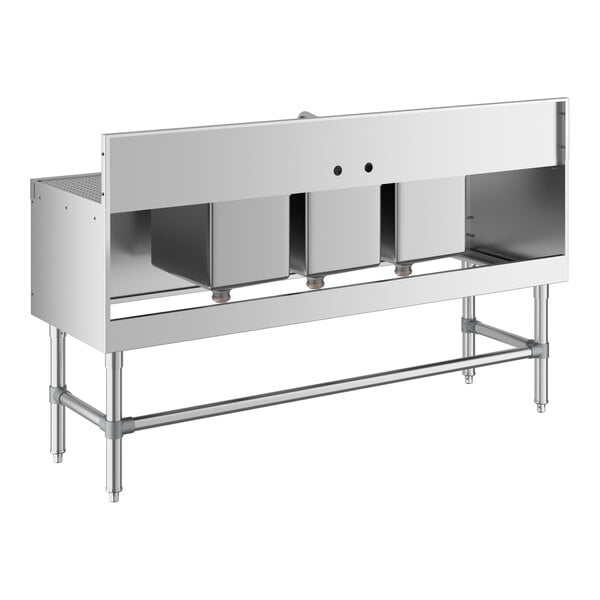 A stainless steel three-compartment sink with two side drainboards and a backsplash, supported by metal legs.