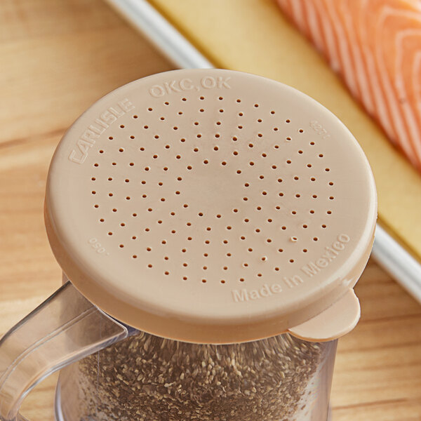 A beige circular lid with holes on a container.