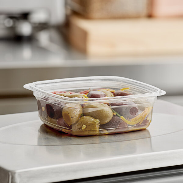 A Pactiv plastic deli container filled with olives.