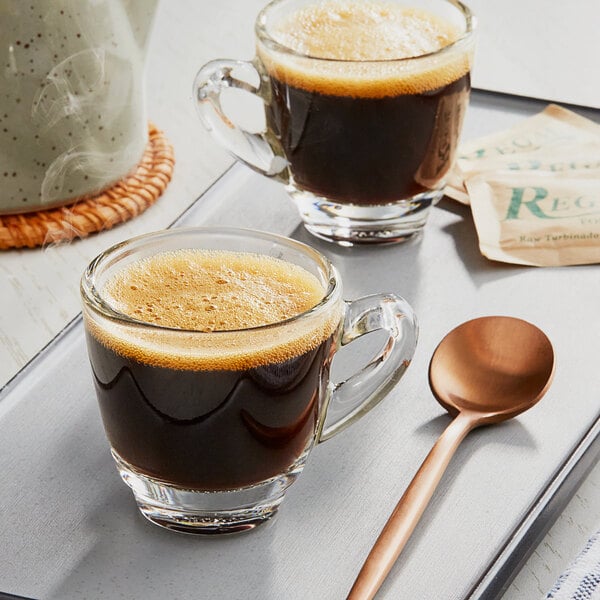 A tray with two glass cups of Lavazza Espresso Maestro Dek Decaf coffee.