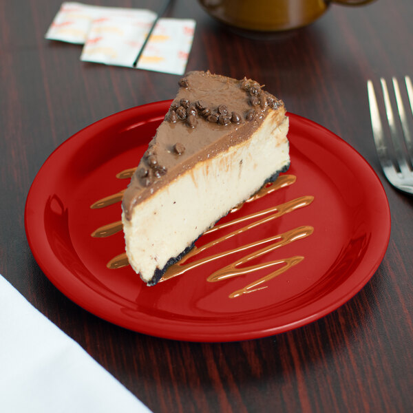 A slice of cheesecake on a red Carlisle Sierrus melamine pie plate.