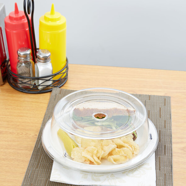 A clear plastic Carlisle plate cover on a plate of food.