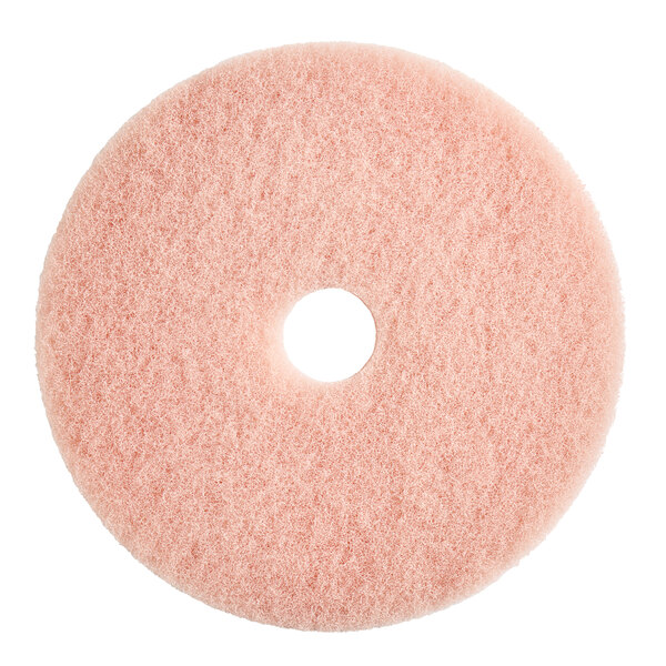 A Lavex pink circular floor pad with a hole in the middle.