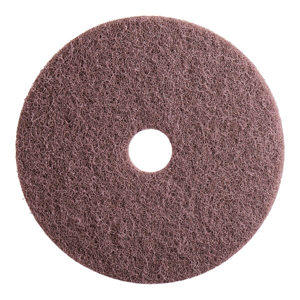 A brown abrasive disc with a hole in the middle.