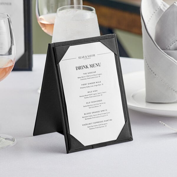 An Acopa Prime black 2-view table tent holding a menu on a table.