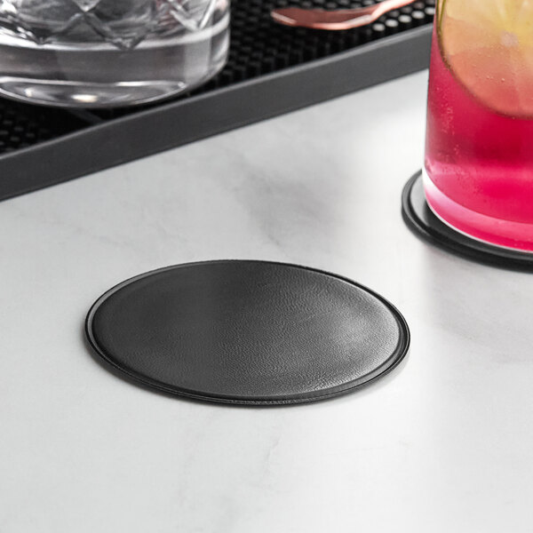A black Choice drink coaster with a glass on it.