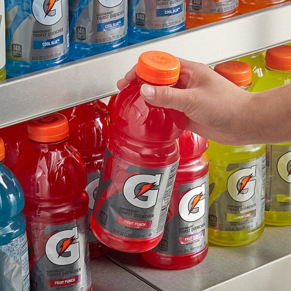 A hand holding a bottle of Gatorade Thirst Quencher Fruit Punch sports drink.