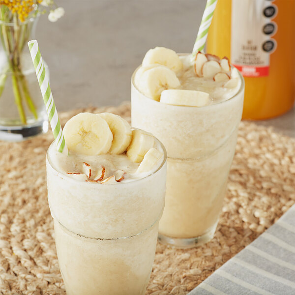 Two glasses of banana milkshakes with straws made with SHOTT Banana Real Fruit Flavoring syrup.