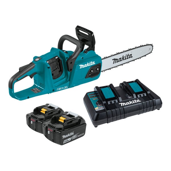 A close-up of a blue and black Makita chainsaw with two black and blue batteries and a dual port charger.