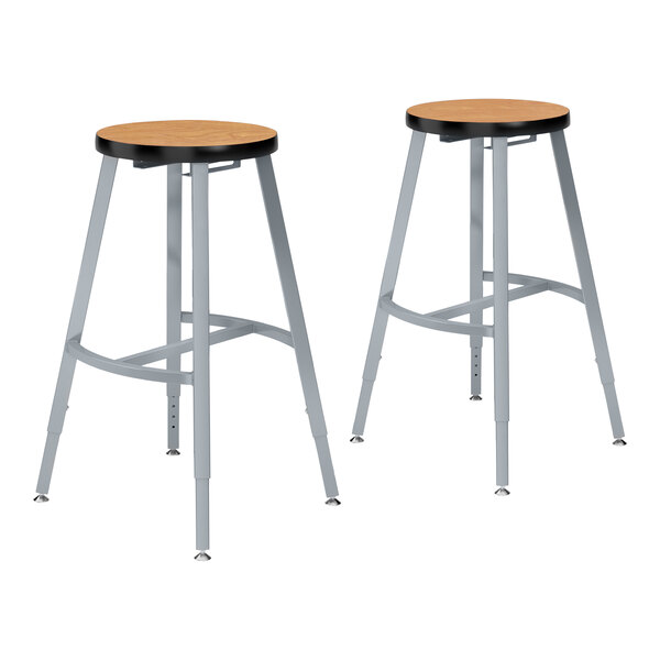 Two National Public Seating lab stools with Bannister Oak seats and metal legs.