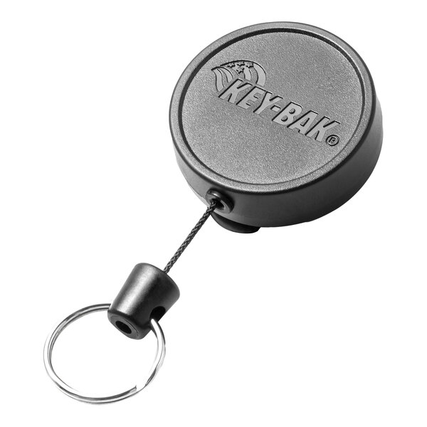 A close-up of a black KEY-BAK keychain with a metal key ring.