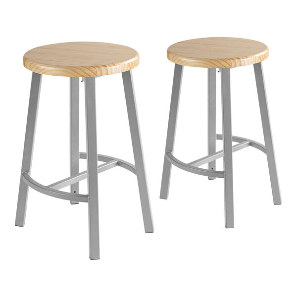 A pair of National Public Seating lab stools with wooden seats and metal legs.
