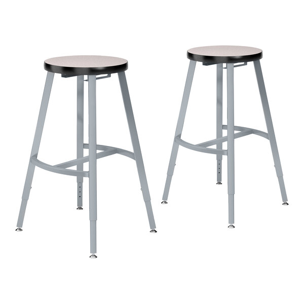 A pair of National Public Seating metal lab stools with gray wooden seats.