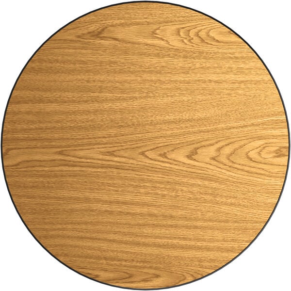 A Lancaster Table & Seating round laminated wood table top with walnut and oak finishes.