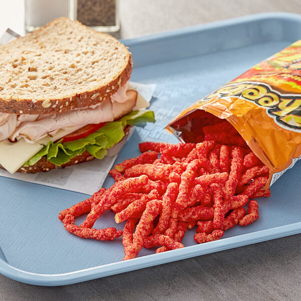 A sandwich and Cheetos on a tray with a bag of Cheetos.