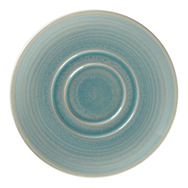 A close-up of a RAK Porcelain blue and white saucer with a circular pattern.
