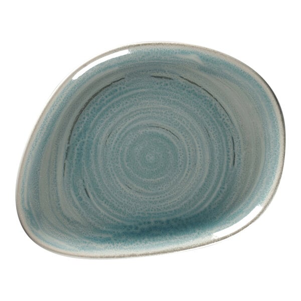 A close-up of a blue and white RAK Porcelain flat organic plate with a spiral design.