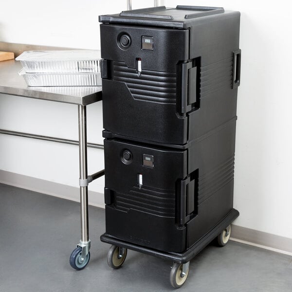 A black Cambro Ultra Camcart holding a black rectangular food storage container.