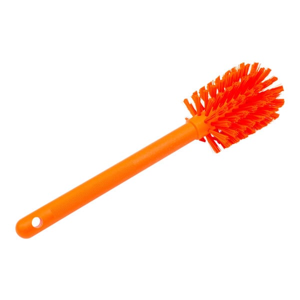 A Carlisle orange plastic bottle cleaning brush with a handle.