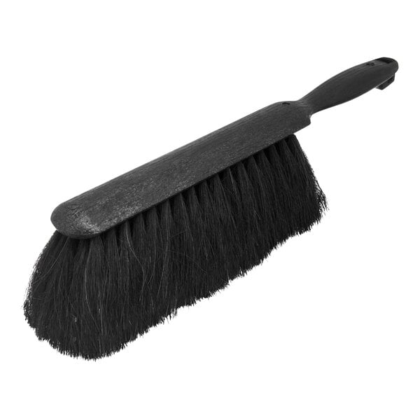 A close-up of a black Carlisle counter brush with a handle.