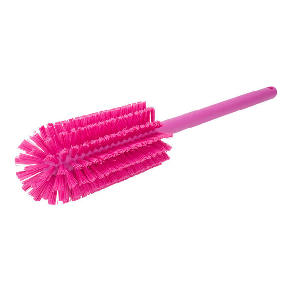 A close-up of a pink Carlisle Sparta bottle cleaning brush with a handle.