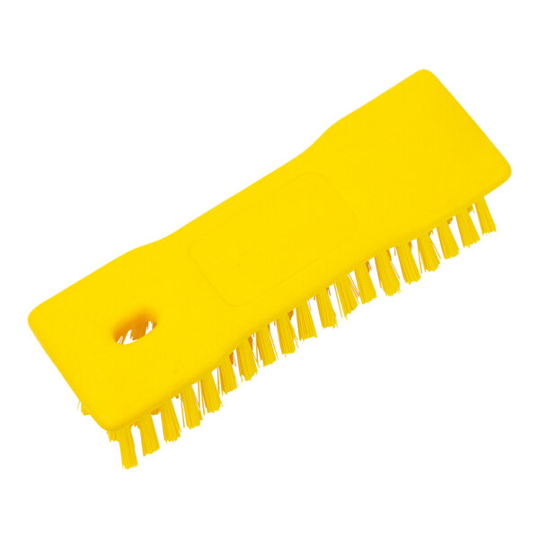 A Carlisle yellow plastic handheld scrub brush with bristles.