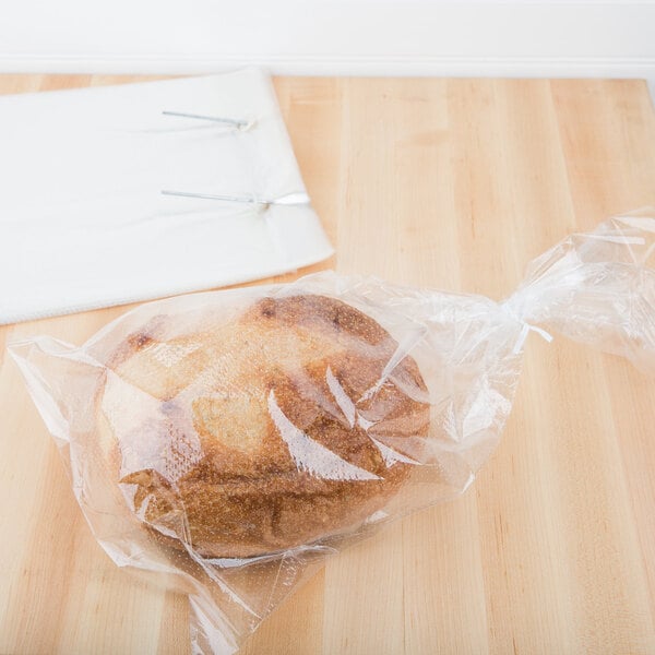 A loaf of bread in a plastic bag on a counter.