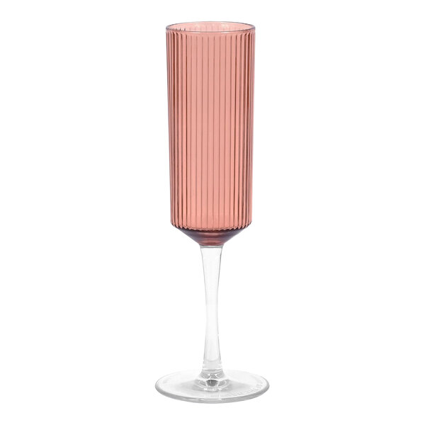 A Front of the House rose plastic champagne flute with a long stem and stripe design filled with pink liquid.