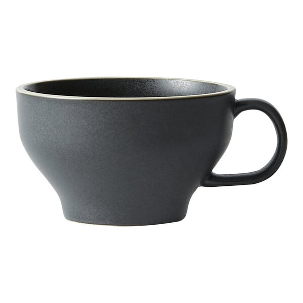 A close up of a black stoneware espresso cup with a handle.