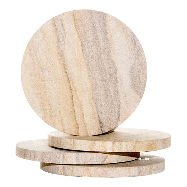 A stack of four round natural sandstone coasters.