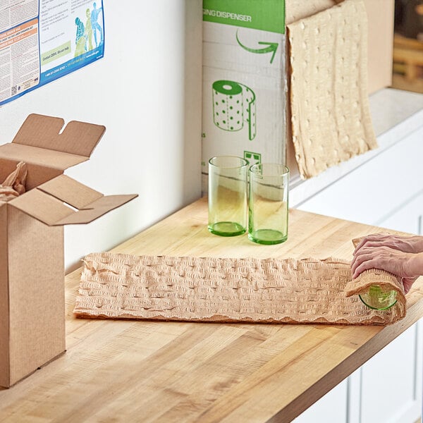 A person using ecoMAX Care perforated brown packing paper to pack a cardboard box.