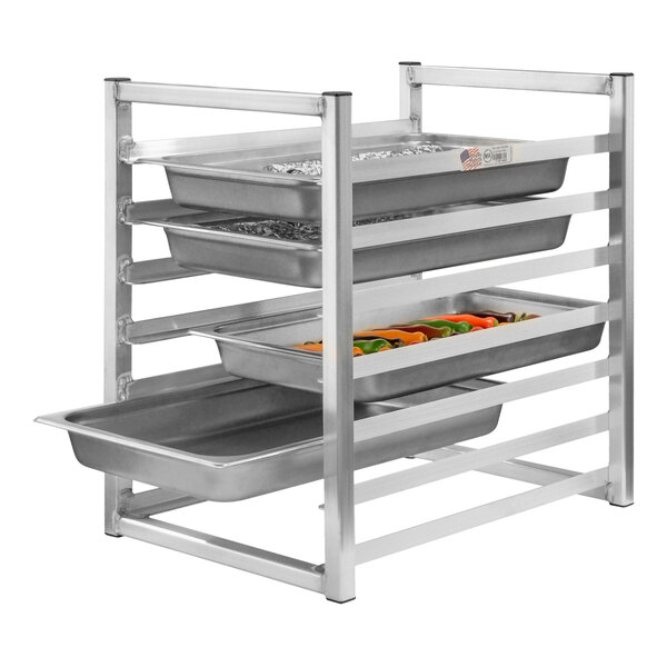 A New Age aluminum rack with trays of food on a counter.