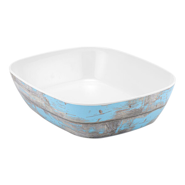 A white bowl with blue rustic paint on the inside and a blue rim.
