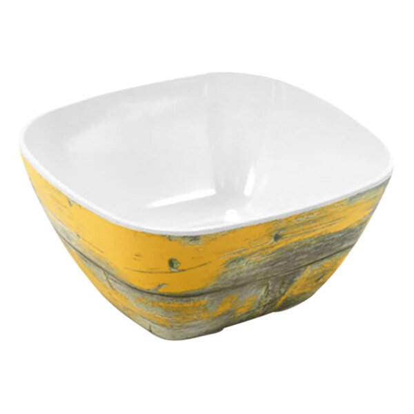 A Dalebrook rustic yellow melamine crock with a yellow center and wooden rim.