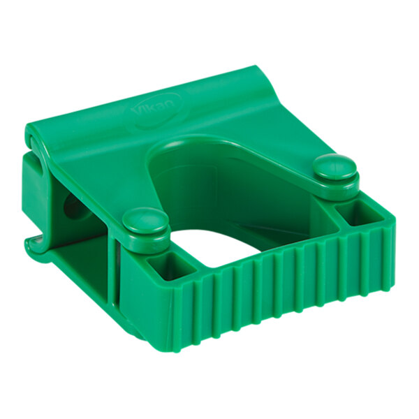 A green plastic Vikan wall bracket with two holes.