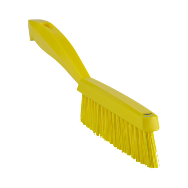A close-up of a yellow brush with a short handle.