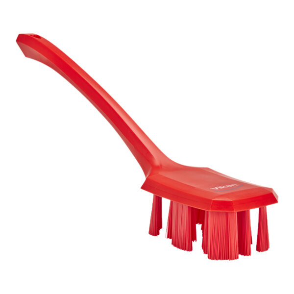 A red Vikan hand brush with a long handle.