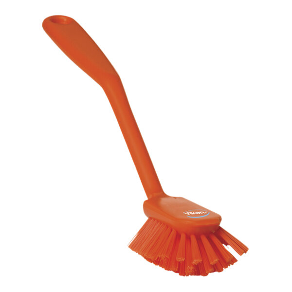 An orange Vikan dish brush with a scraping edge and medium bristles.
