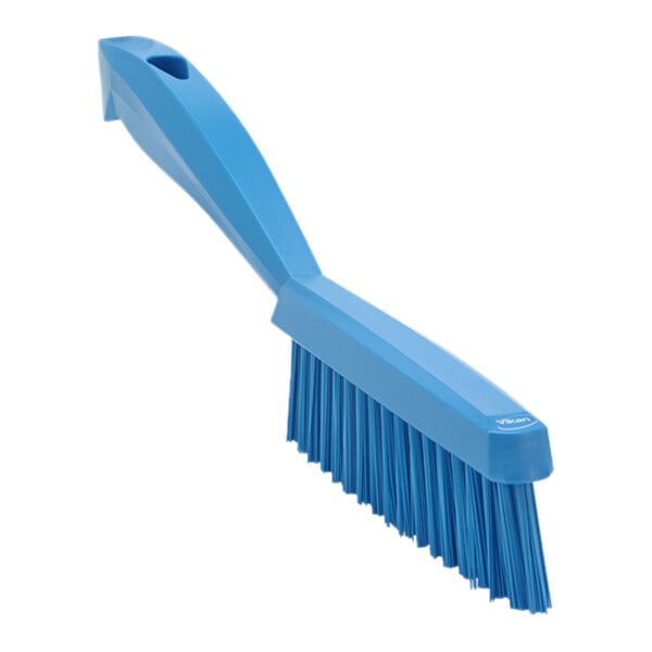 A blue brush with a short handle and blue bristles.