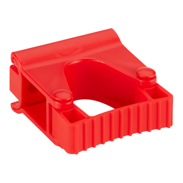 A red plastic Vikan wall bracket with holes.