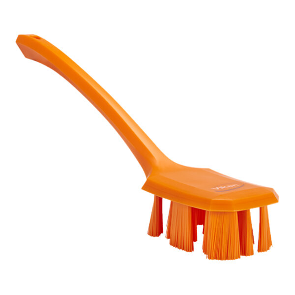 An orange Vikan hand brush with a long handle.