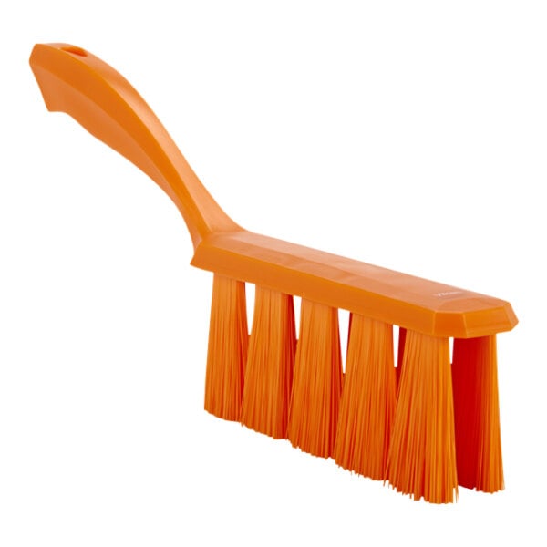 An orange bench brush with an orange plastic handle.