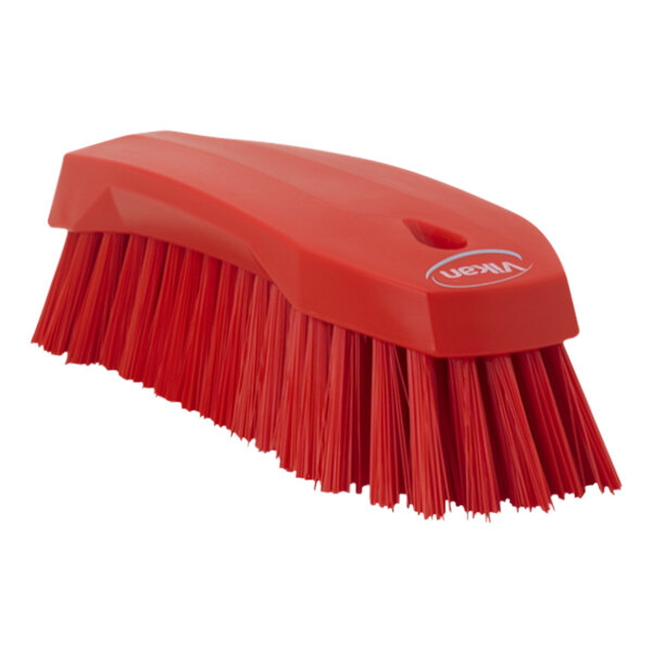 A red Vikan scrub brush with a handle.
