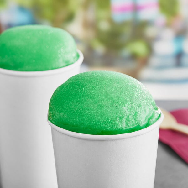 Two cups of Philadelphia Water Ice Mint Italian Ice with spoons.