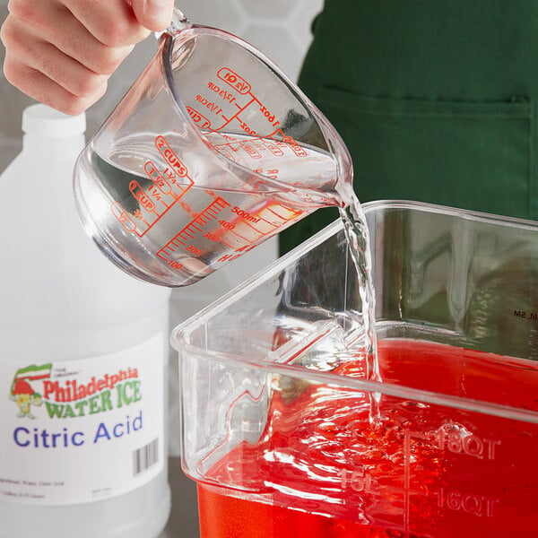 A person pouring Philadelphia Water Ice Citric Acid Solution into a container.