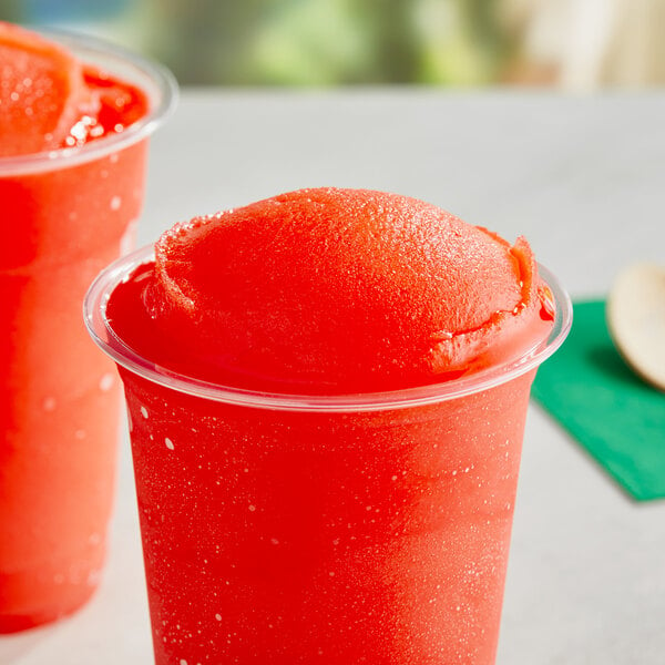A white cup of red Philadelphia Water Ice Watermelon Italian Ice with a straw.