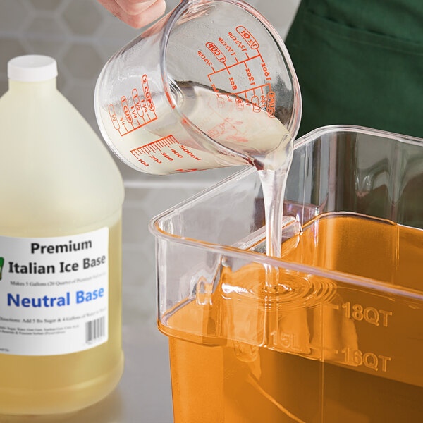 A person pouring Philadelphia Water Ice Italian Ice Base from a measuring cup into a container.